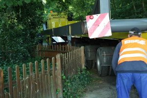 Die Auflagefläche des Stahltransporters liegt über dem Zaun an der Gedenkstätte und übder den Tafeln des Histoischen Lehrpfades. Alles war langfristig geplant und durchdacht.