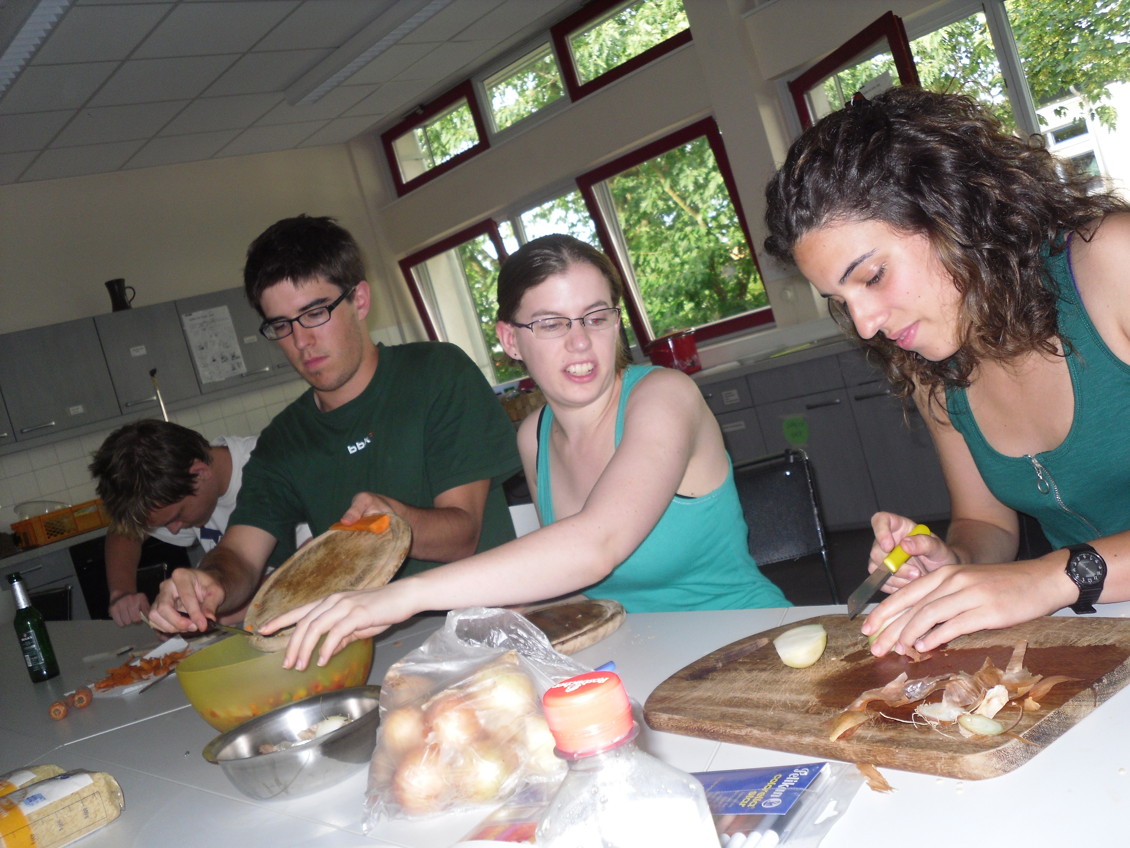 Während eines work-and-study Camps: Teilnehmerinnen und Teilnehmer bereiten gemeinsam das Essen zu.
