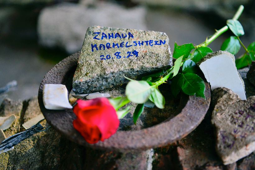 Viele Gäste hatten eine Blume mitgebracht und legten sie im Keller zusammen mit dem selbst beschrfteten Stein nieder. Diesen Stein beschriftete Tal Segev, die Enkelin von Zahava ("Goldi) Mermelstein, die als 15-jähriges Mädchen im Walldorfer Lager inhaftiert war. Tal hat 2005 - im Rahmen des damaligen International work and study camps - diesen Herdring selbst ausgegraben.