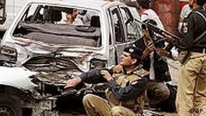 Das Bild zeigt, wie sich beim Angriff auf zwei Ahmadiyya Moscheen in Lahore (2010) Offiziere schutzsuchend hinter Autos verstecken.